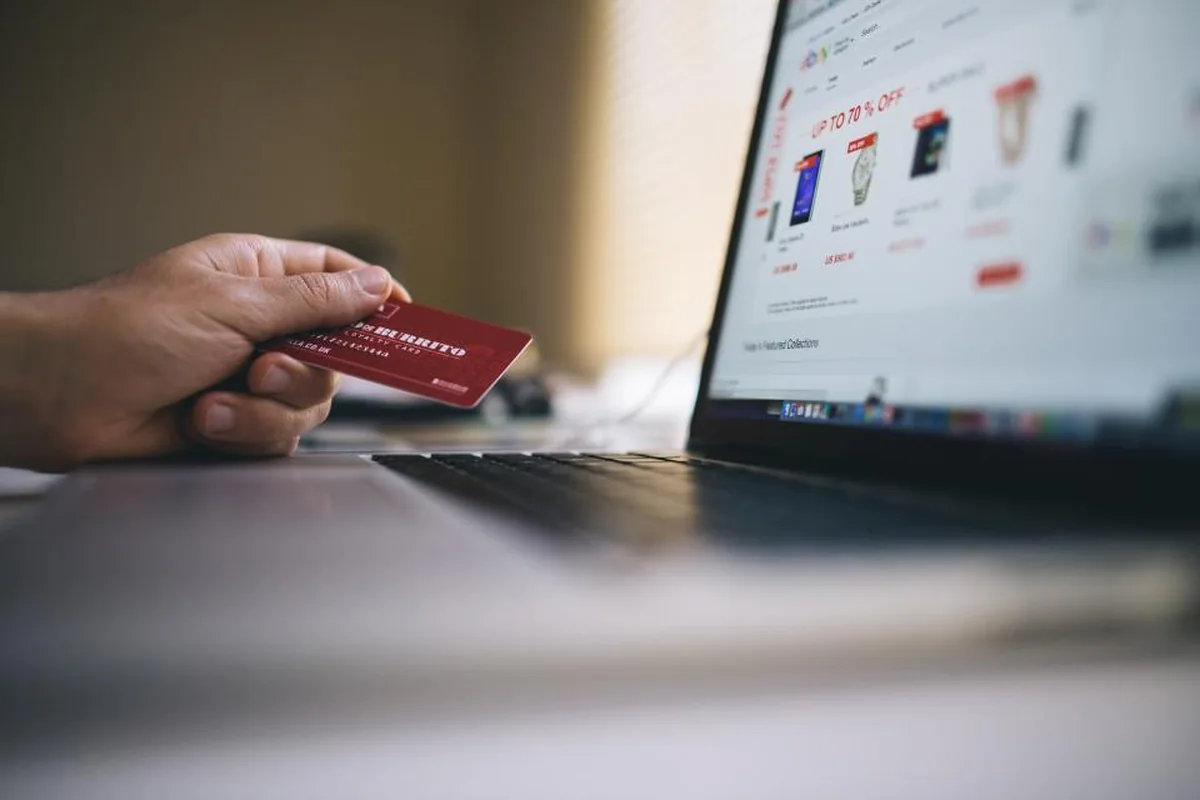Laptop open on an online store checkout beside a stack of parcels ready to ship, representing ecommerce websites built for Indian businesses