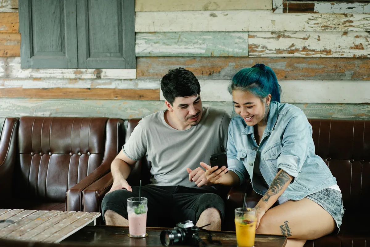 Couple browsing a smartphone together in a cafe