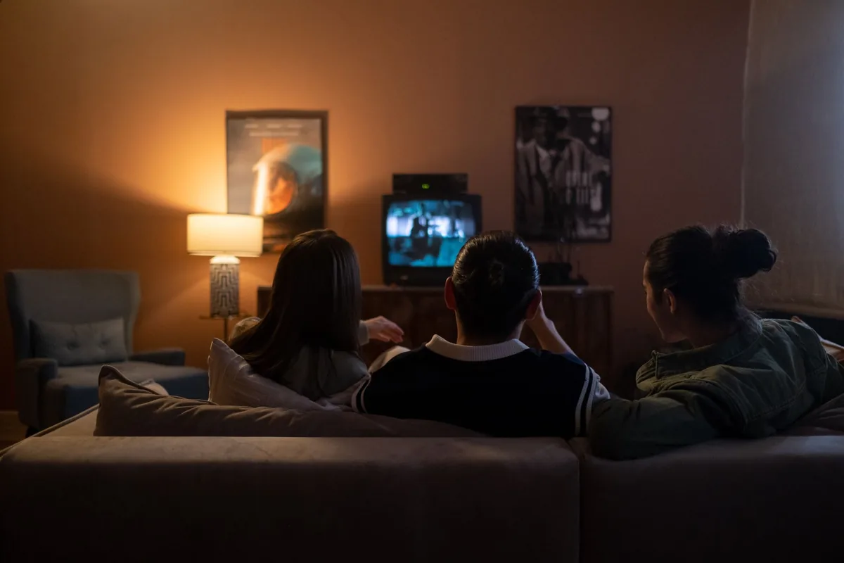Three friends watching a film at home