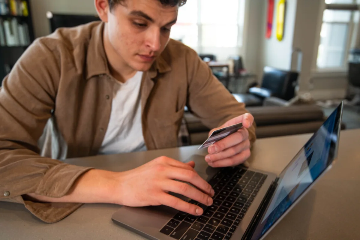 Person paying by card on an online store on a laptop, representing ecommerce built for US brands